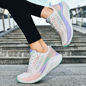 A person wearing pastel iridescent sneakers with black leggings, shown from the knees down on outdoor stone steps under a blue sky.