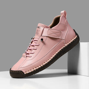 Pink sneaker with black sole on a gray background