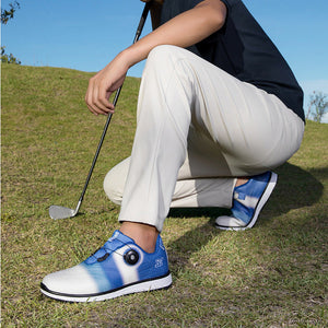 A person crouching on a grassy hill outdoors wearing white golf pants and blue-and-white golf shoes, with a golf club resting beside them.