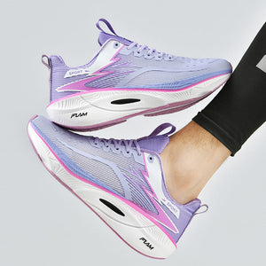 Purple and white running shoes worn by a person on a light gray background