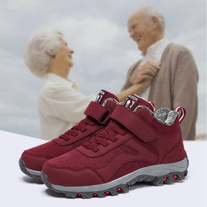 A pair of red slip-on sneakers with gray soles and a silver-gray textured lining, shown in front of a blurred background image of an elderly couple smiling. Text at the top reads 'Information display # Information display'.