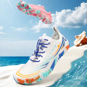 A white athletic sneaker with blue, orange, and turquoise accents is shown floating above a beach scene with ocean water, sand, and a seashell. A second shoe floats above it, showing the pink and turquoise patterned sole.