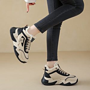 A person wearing black skinny jeans and chunky low-top sneakers with cream, black, and white layered panels and thick black soles, shown against a plain beige studio background. Text banners appear at the top and bottom.