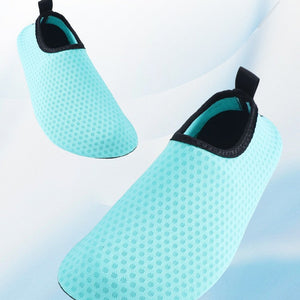 Two light aqua mesh slip-on water shoes shown on a white and pale blue background with marketing text at the top describing toe design and lifting webbing.