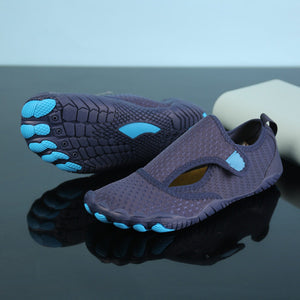 A pair of dark purple water shoes with bright blue accents on the sole and footbeds, displayed on a reflective black surface.