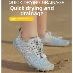 A pair of light gray and light blue water shoes shown on feet on sand, with text overlays reading 'QUICK DRYING DRAINAGE' and 'Quick drying and drainage'.