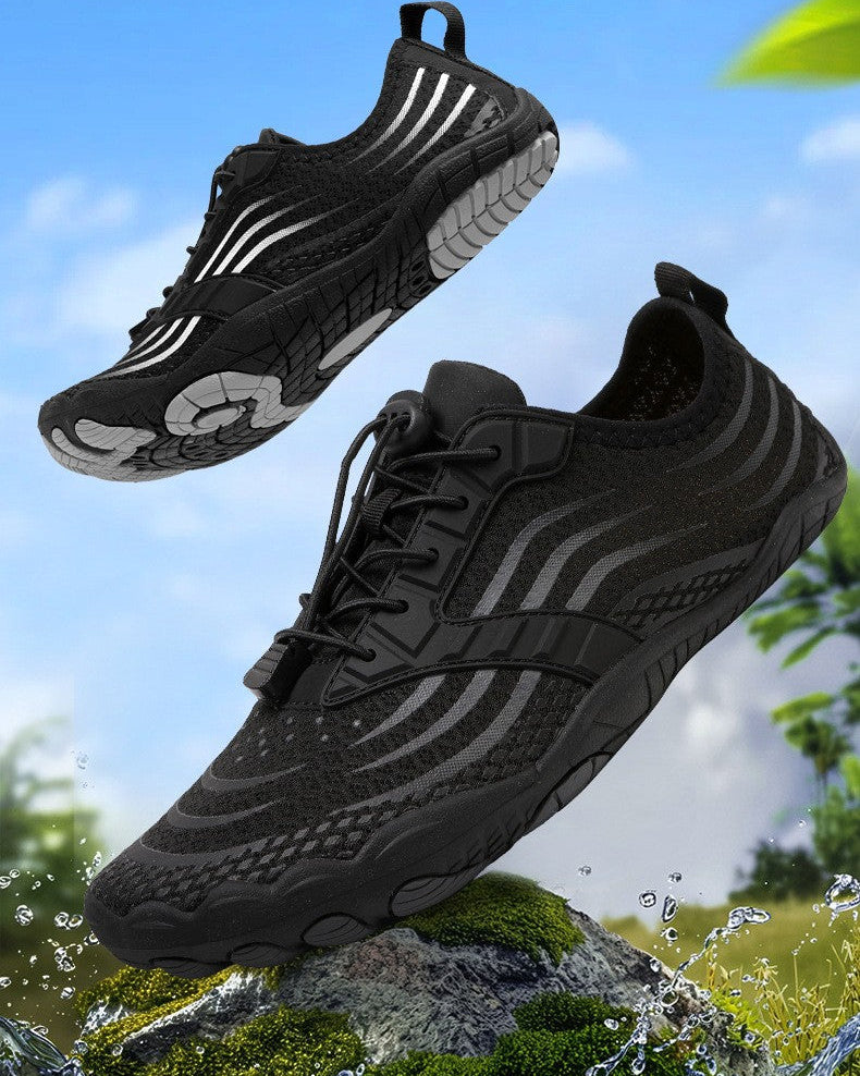 Black Jingyo shirono couple style outdoor water shoes shown in a floating product composition over a blurred outdoor background with water splashes and greenery.