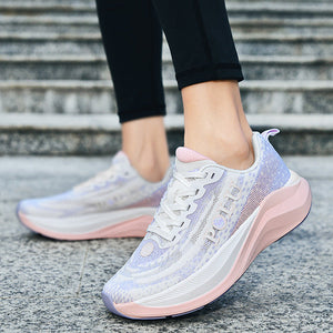 A pair of women's athletic sneakers in a light lavender and pink colorway, shown being worn with black leggings on outdoor stone steps.