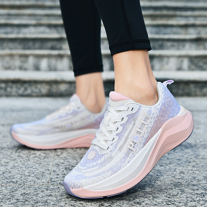 A pair of women's athletic sneakers in a light lavender and pink colorway, shown being worn with black leggings on outdoor stone steps.