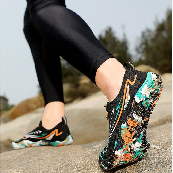 A person outdoors wearing black athletic leggings and colorful trail running shoes with a textured, floral-like sole. Text at the top describes the shoe sole features.