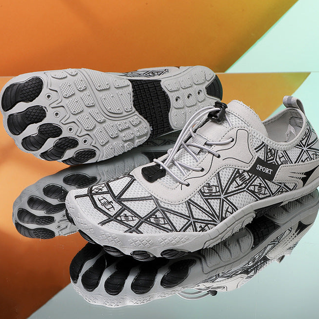 White athletic shoes with black sole design on a reflective surface with an orange and gray background.