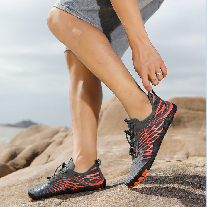 Person wearing black and orange shoes on a rocky surface with a light blue border.