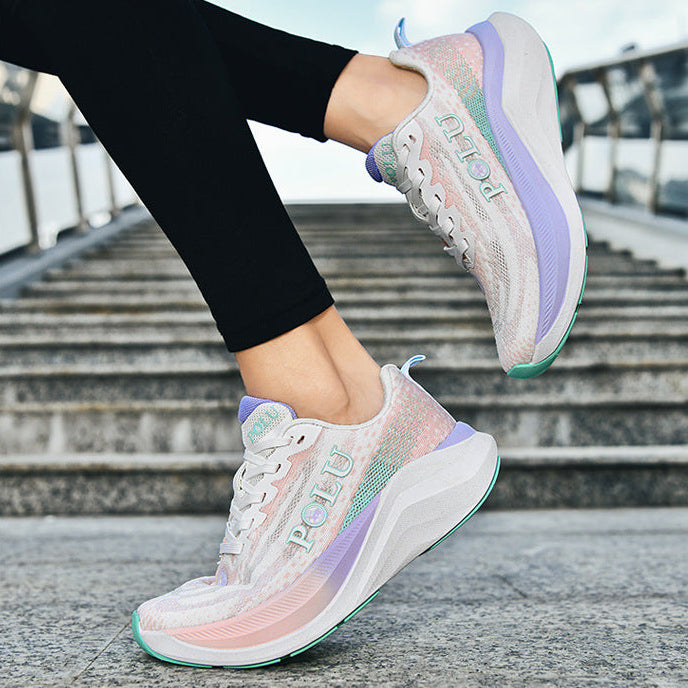 A person wearing pastel iridescent sneakers with black leggings, shown from the knees down on outdoor stone steps under a blue sky.