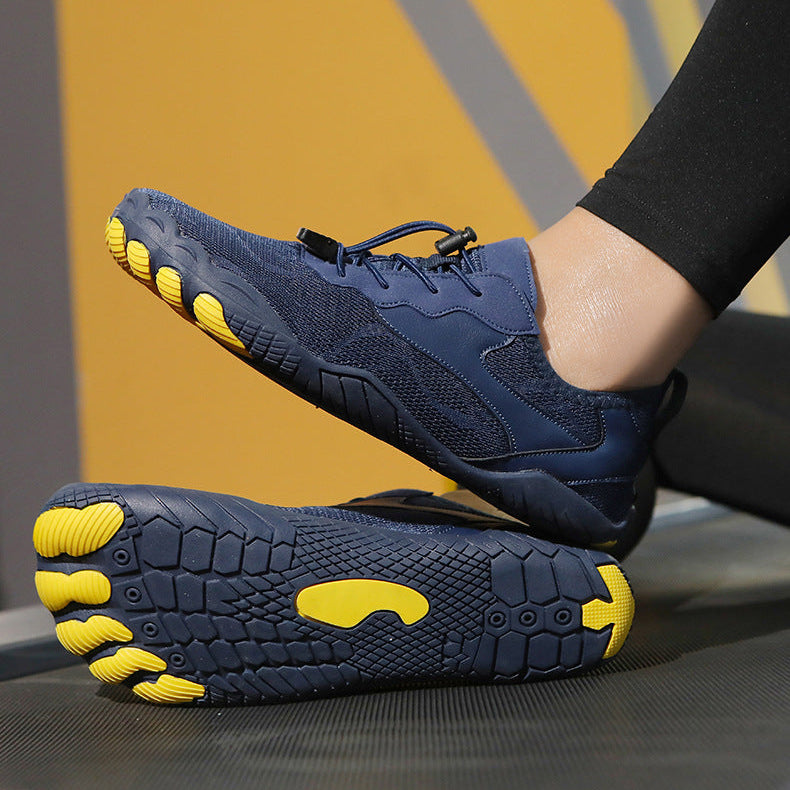 A pair of minimalist toe-touch athletic shoes in navy blue and bright yellow, with one shoe shown from the side and the other from the sole, worn with black leggings.