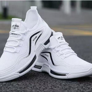White athletic shoes with black accents on a road surface