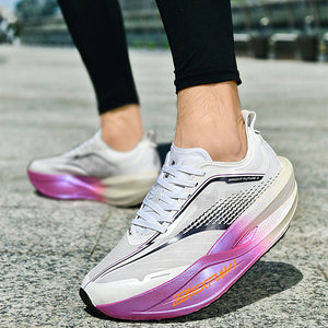 White sneakers with pink and purple gradient sole on a concrete surface