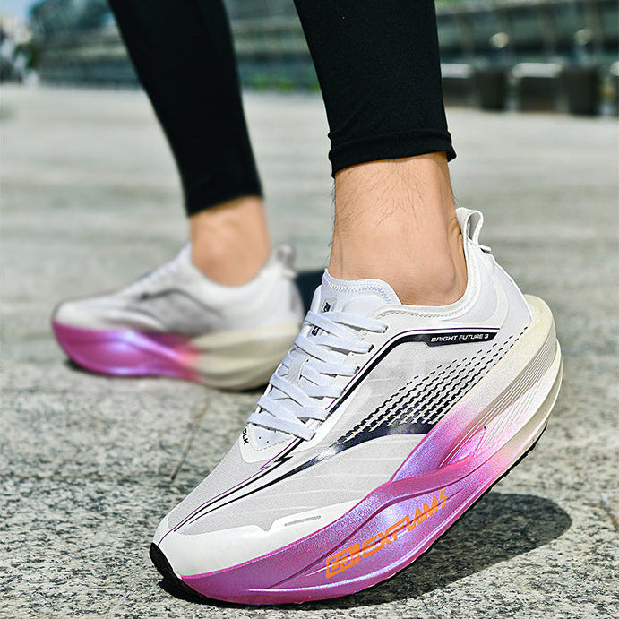 White sneakers with pink and purple gradient sole on a concrete surface