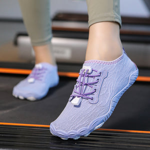 A person wearing a light lavender knit athletic shoe with purple laces, shown stepping onto a treadmill. The matching second shoe is visible in the background.