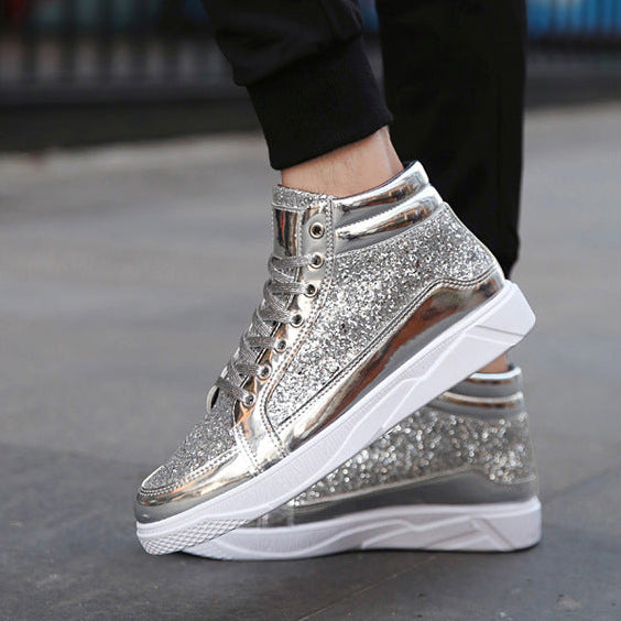 Silver glitter high-top sneakers with white soles worn by a person on a blurred background