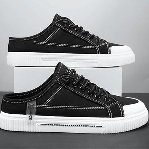 Black sneakers with white soles on a gray background