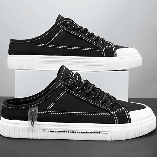 Black sneakers with white soles on a gray background
