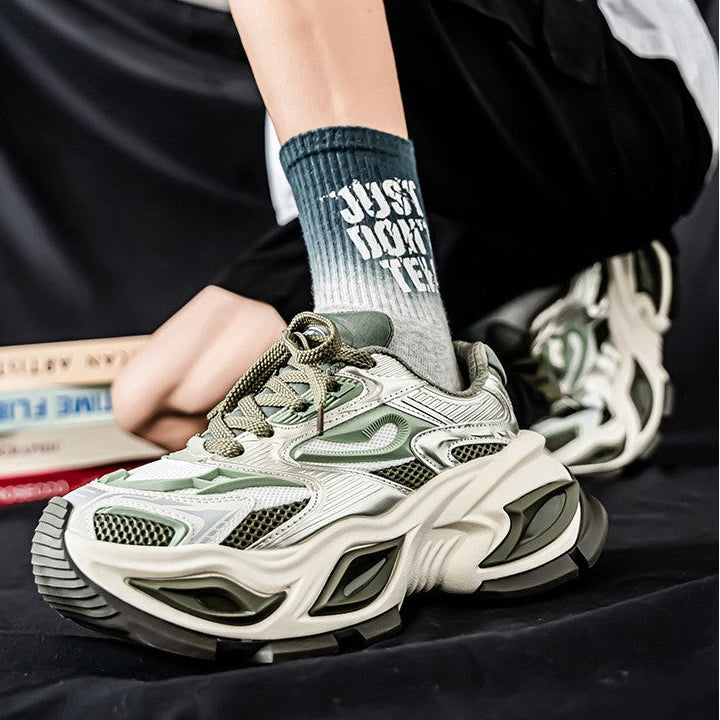 A person seated indoors wearing chunky white and olive green chunky sneakers, black shorts, and a dark gray sock with white text reading 'JUST DUNGE'. The image includes the text 'Product/catalog' at the top.