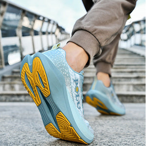 A close-up of a person's foot wearing a light blue and yellow running shoe on outdoor concrete stairs, with the side and sole of the shoe clearly visible.
