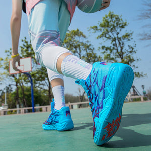 Person playing basketball on an outdoor court wearing colorful shoes and outfit.