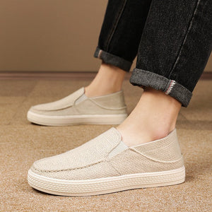 A pair of casual slip-on loafers in a light beige linen-like material, shown being worn with dark cuffed jeans on a neutral indoor floor. Text below provides product information including size 39-45 and color black gray beige.