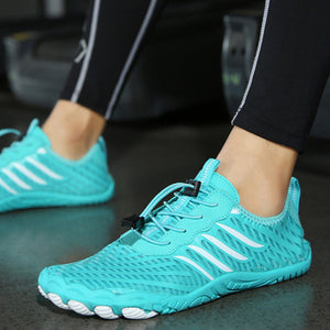 A close-up of a person wearing bright turquoise athletic sneakers with white side stripes and black laces, standing on a dark gym floor.