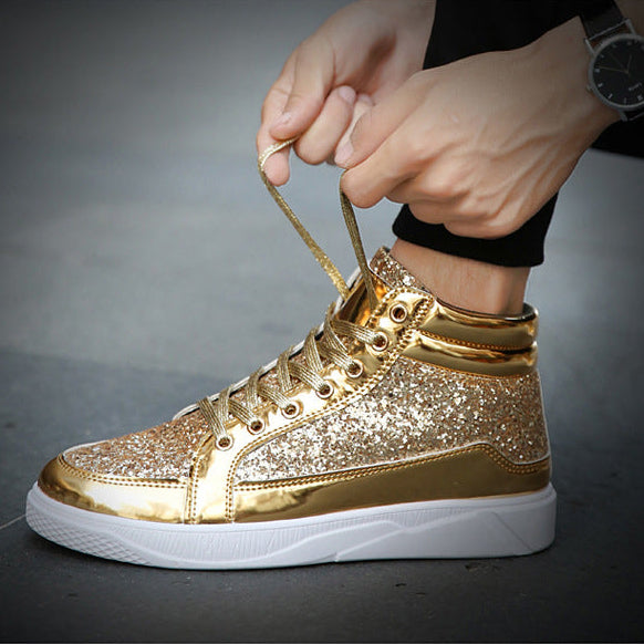 Gold glittery sneaker being worn with a dark background