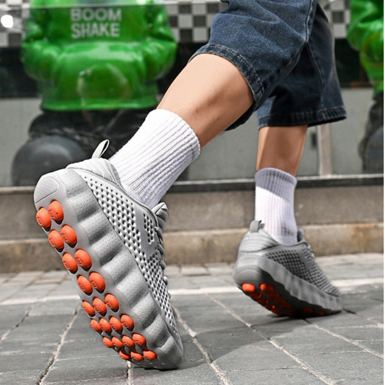 Person wearing gray shoes with orange sole patterns on a checkered floor background