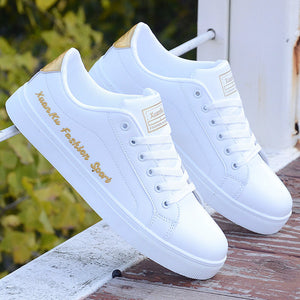 White ActiveCore sneakers with gold heel and side accents displayed outdoors