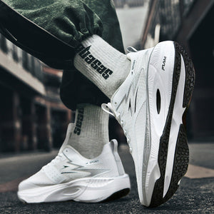 White sneakers with black soles worn by a person on a blurred street background