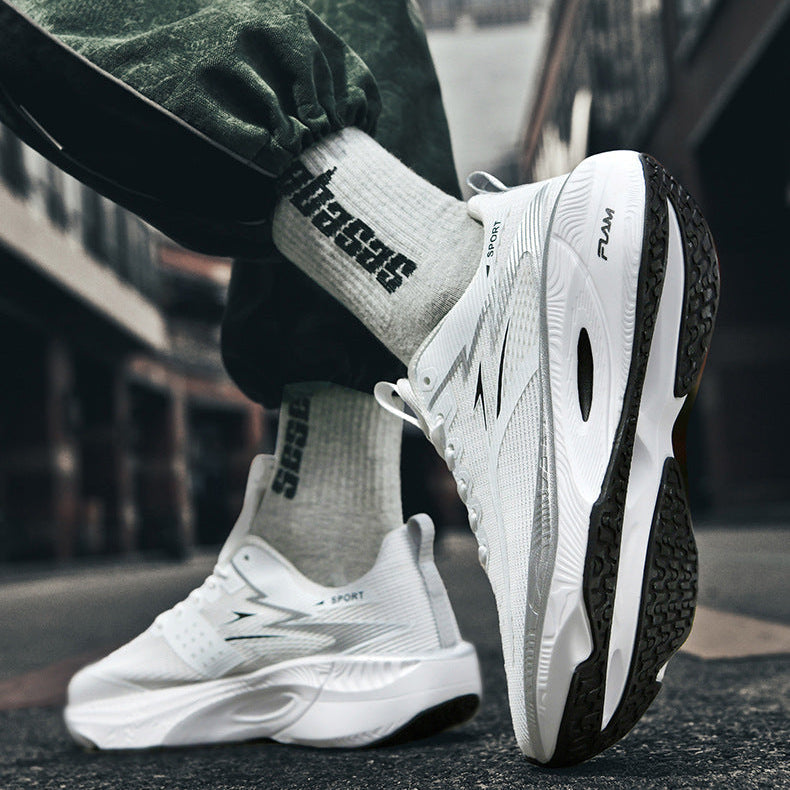 White sneakers with black soles worn by a person on a blurred street background