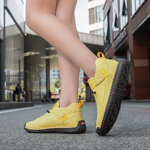 Yellow sneakers worn by a person on a city street.
