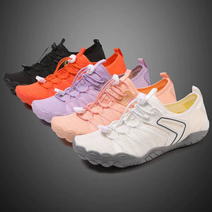 Six athletic sneakers arranged in a diagonal row on a dark gray gradient background, showing color options from black to white and orange to pastel pink, purple, peach, and light gray.