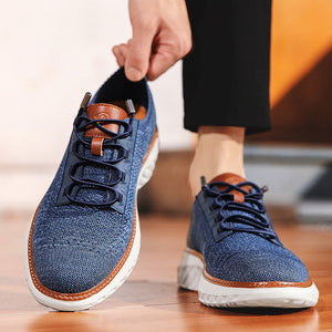 A person wearing a black top and pants is shown holding up a blue textured sneaker, with a second matching sneaker on the floor beside them. The image includes promotional text at the top about the shoe's styling versatility.