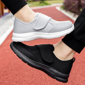Black and gray sneakers with velcro straps on a blurred outdoor background