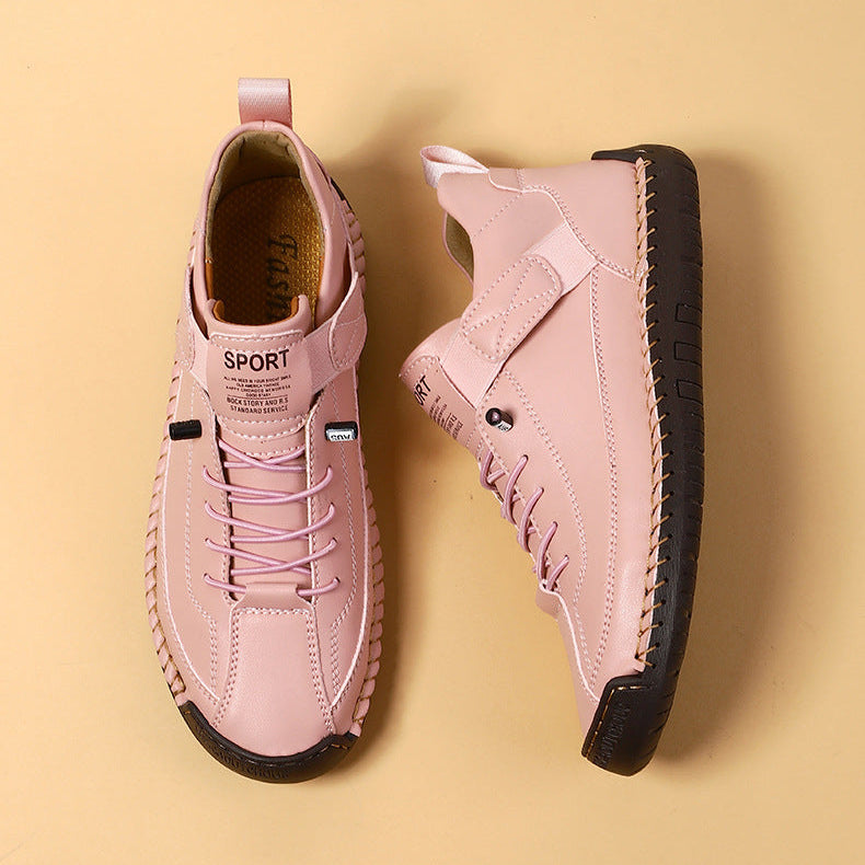 Pair of pink sneakers with black soles on a beige background