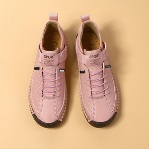 Pair of pink sneakers with black soles on a beige background